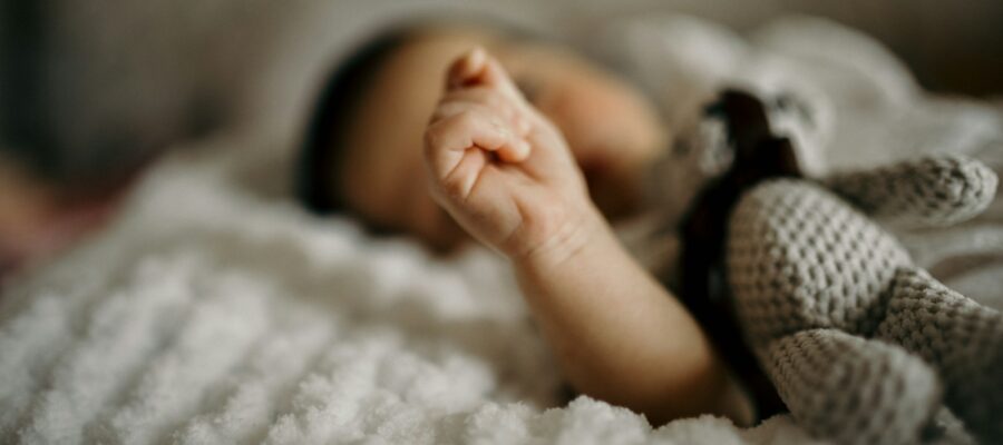 a close up of a baby laying on a blanket